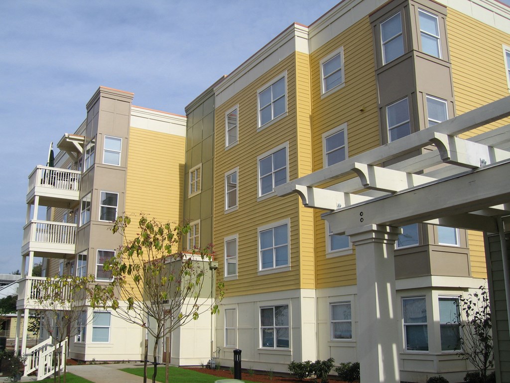a row of yellow and white apartment buildings on a sunny day