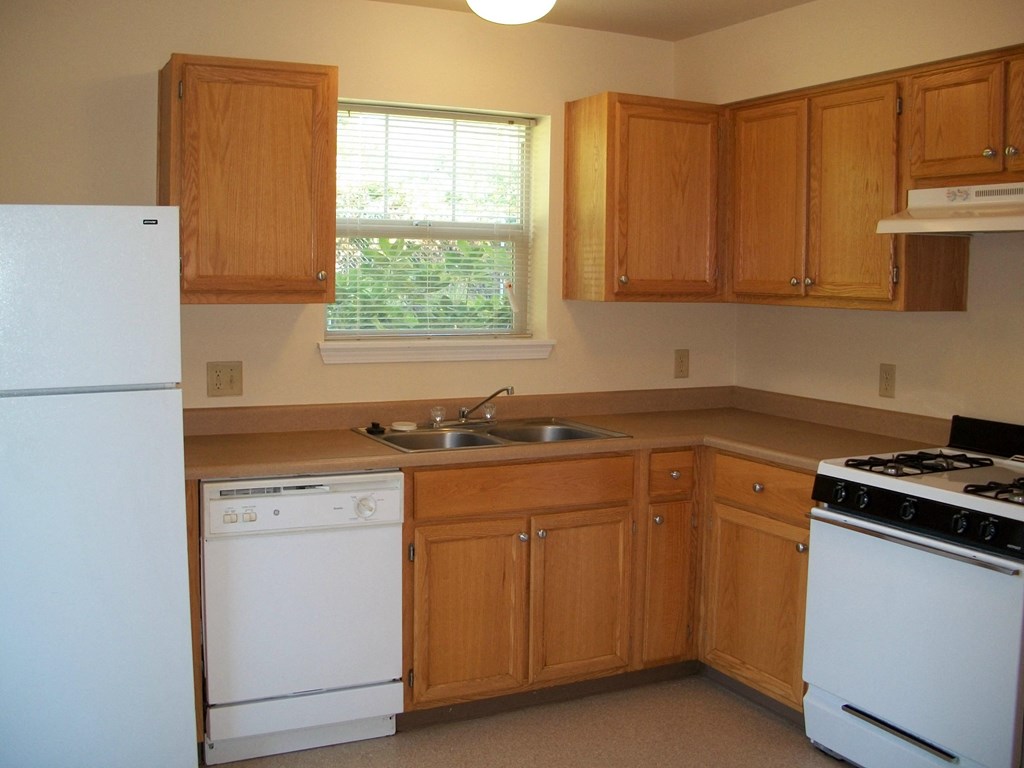 a kitchen with white appliances and wooden cabinets