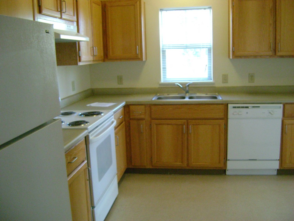 a kitchen with white appliances and wooden cabinets