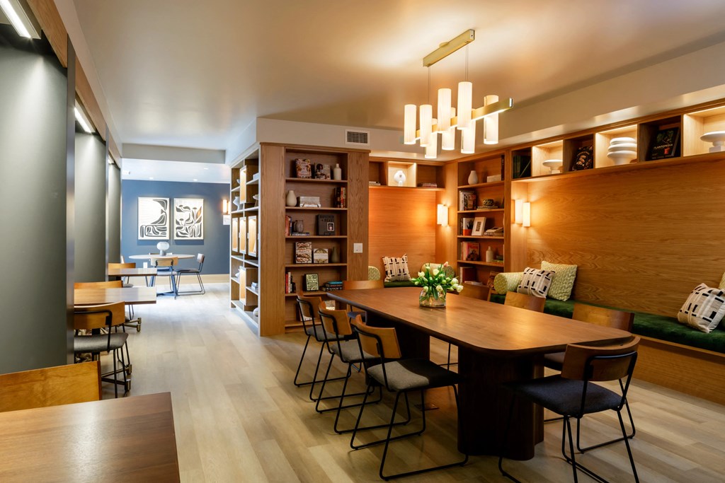 library with books, a long table and side individual tables