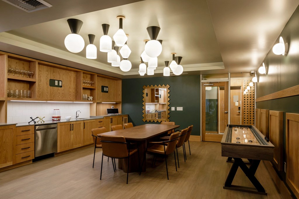 a game room with a long table and a shuffleboard table