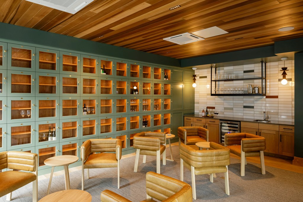 a bar with wooden chairs and a wall with shelves