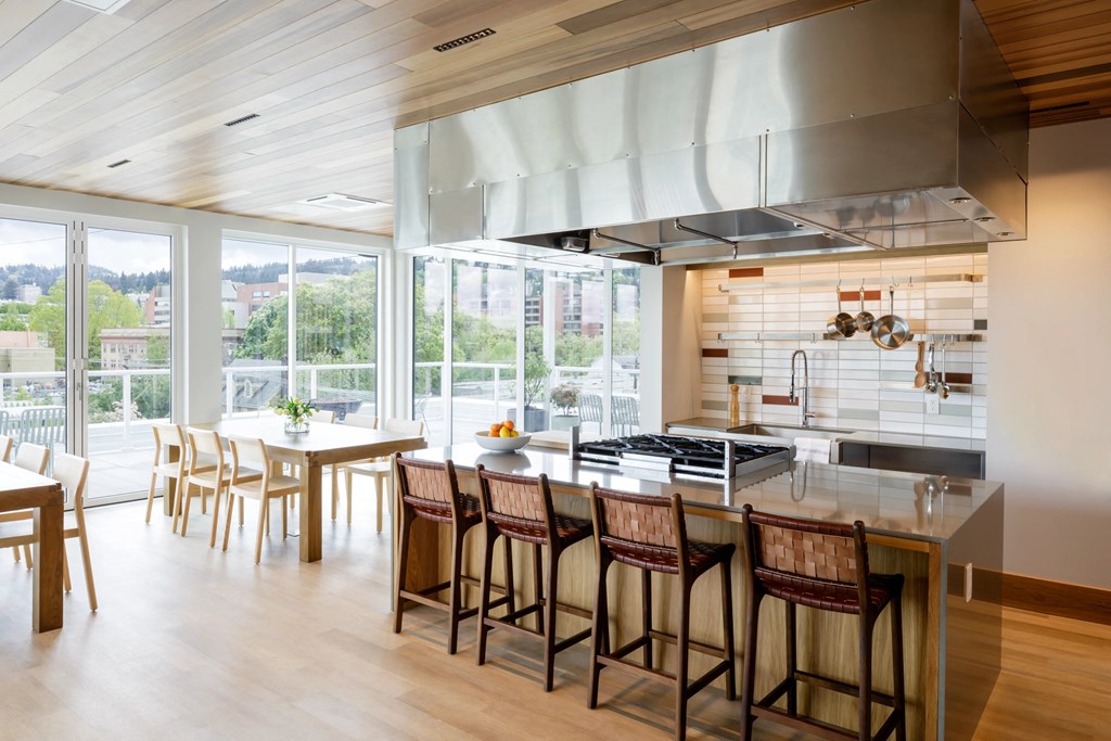 the kitchen and dining area of a modern house with a large kitchen island and chairs