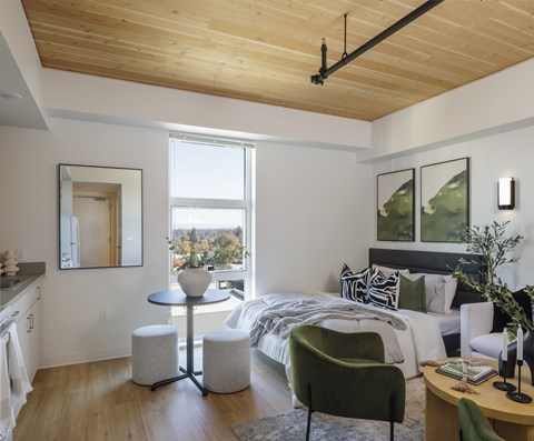 A modern bedroom with a large bed and a green armchair.