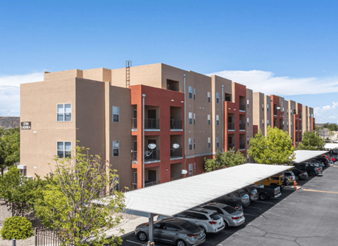 A long building with a parking lot in front.