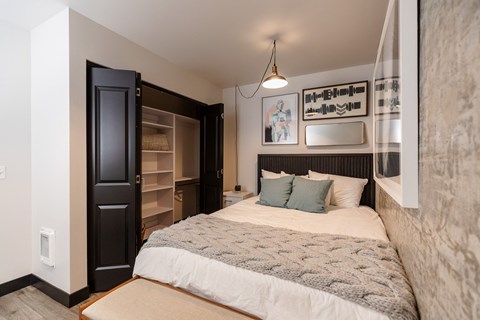 A bedroom with a large bed and a black door.