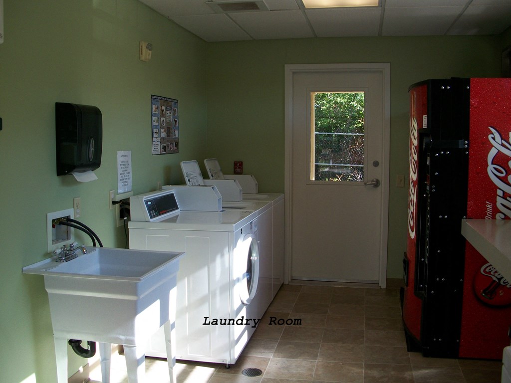 a laundry room with a coke machine and a sink