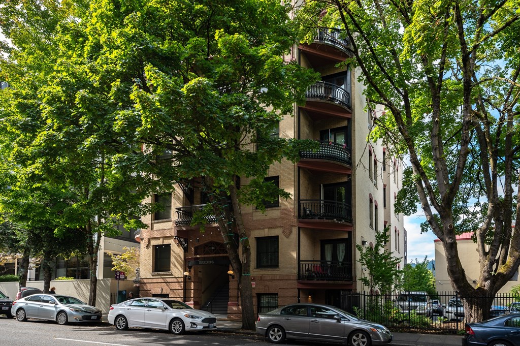 an apartment building with cars parked on the street