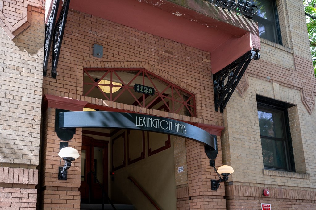 the front of a brick building with an entrance sign
