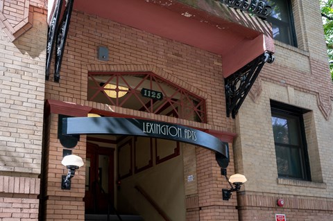 the front of a brick building with an entrance sign and