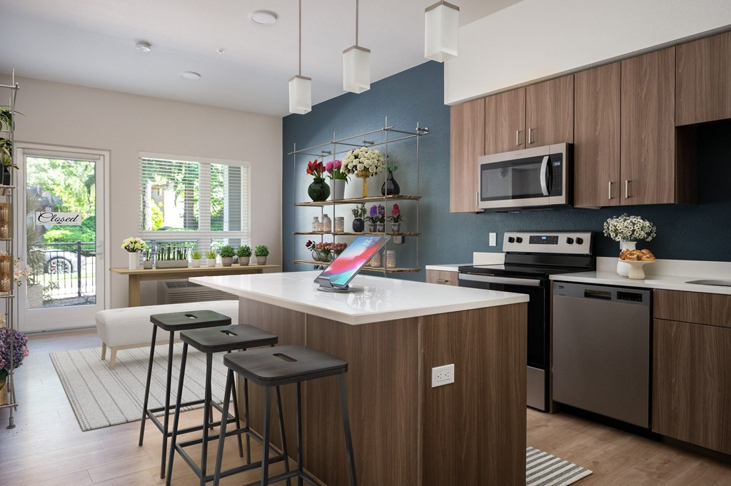 a kitchen with a large island with three bar stools
