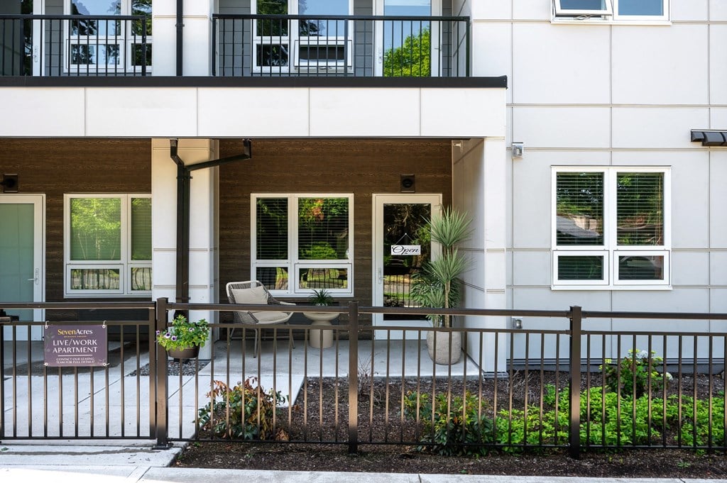 the front of a building with a fence and a patio