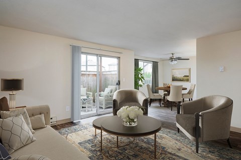 a living room with couches and chairs and a table with flowers