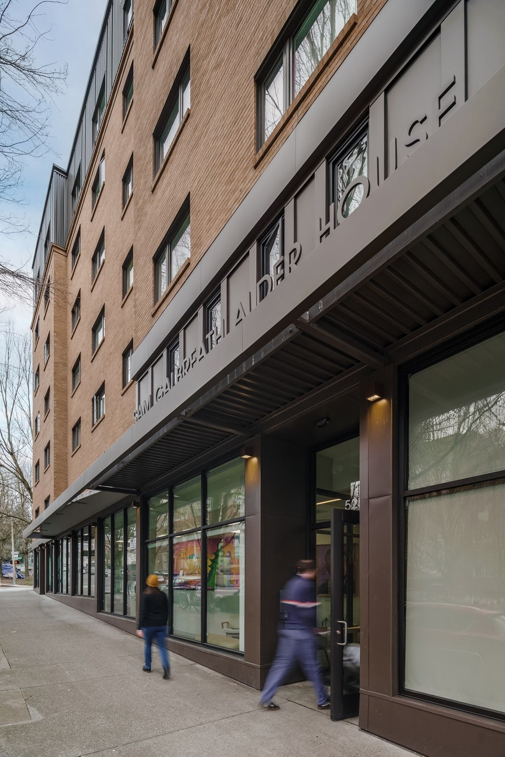 a large brick building with a black facade on the side of a road