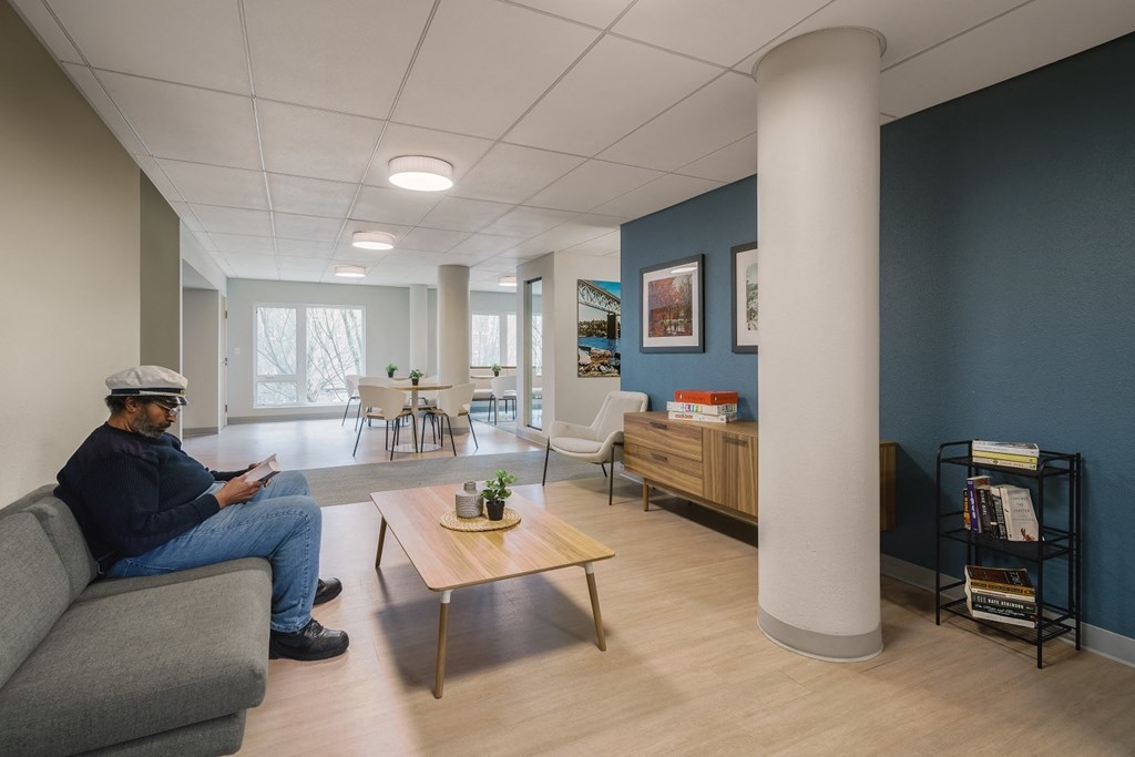 a man sitting on a couch in a room with blue walls