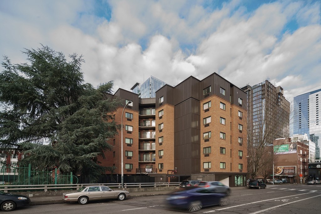 a large brick building with a black facade on the side of a road
