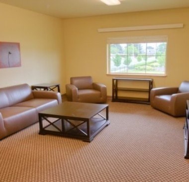 A living room with brown leather furniture and a large window.