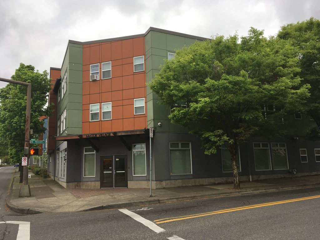 a green and orange building on the corner of a street