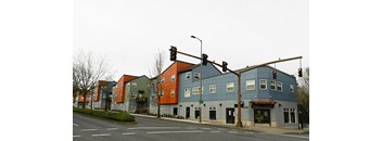 a row of buildings on a street corner at a traffic light