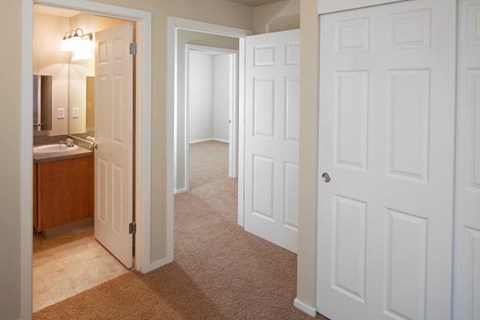 a bedroom with white doors and a bathroom with a sink