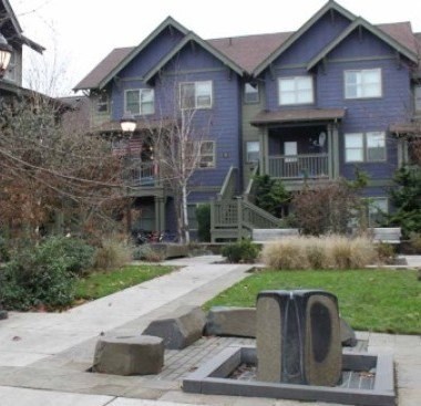 A blue house with a grey front yard.