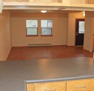 A room with a grey counter and wooden drawers.
