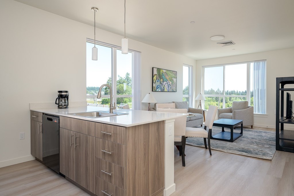 A modern kitchen with a large island and a view of the outdoors.