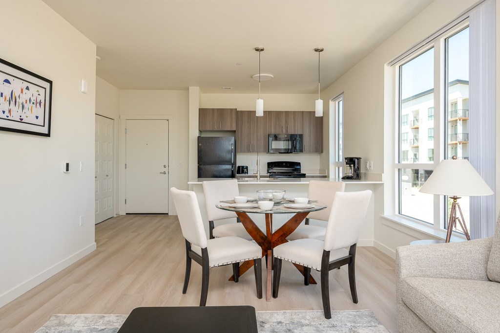 A modern kitchen with a dining table set for two.