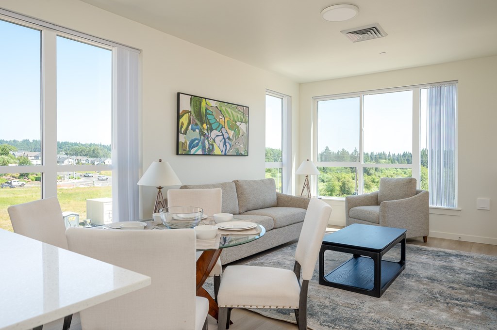 A modern living room with a dining table and chairs.