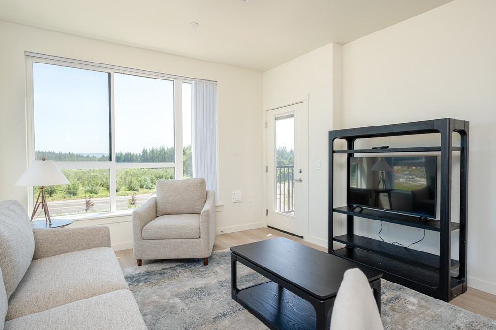 A living room with a black coffee table and a white chair.