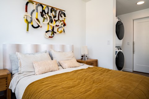 a bedroom with a bed and a wall with a rack of shoes on it at Slabtown Square Apartments, Portland , Oregon