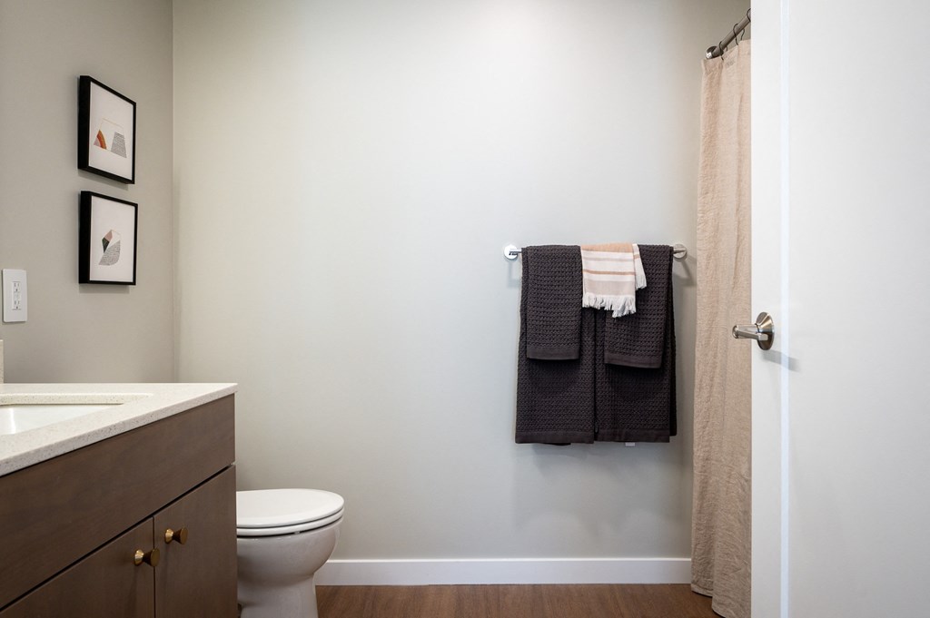 a bathroom with a toilet sink and towel rack and a shower