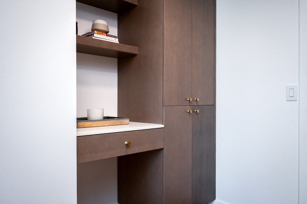 a cupboard with a sink and a shelf in a bathroom
