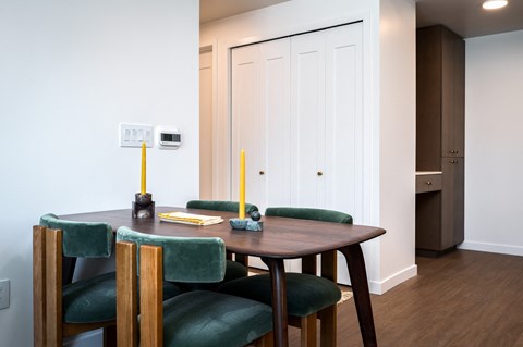 a dining room with a wooden table and green chairs at Slabtown Square Apartments, Oregon, 97209