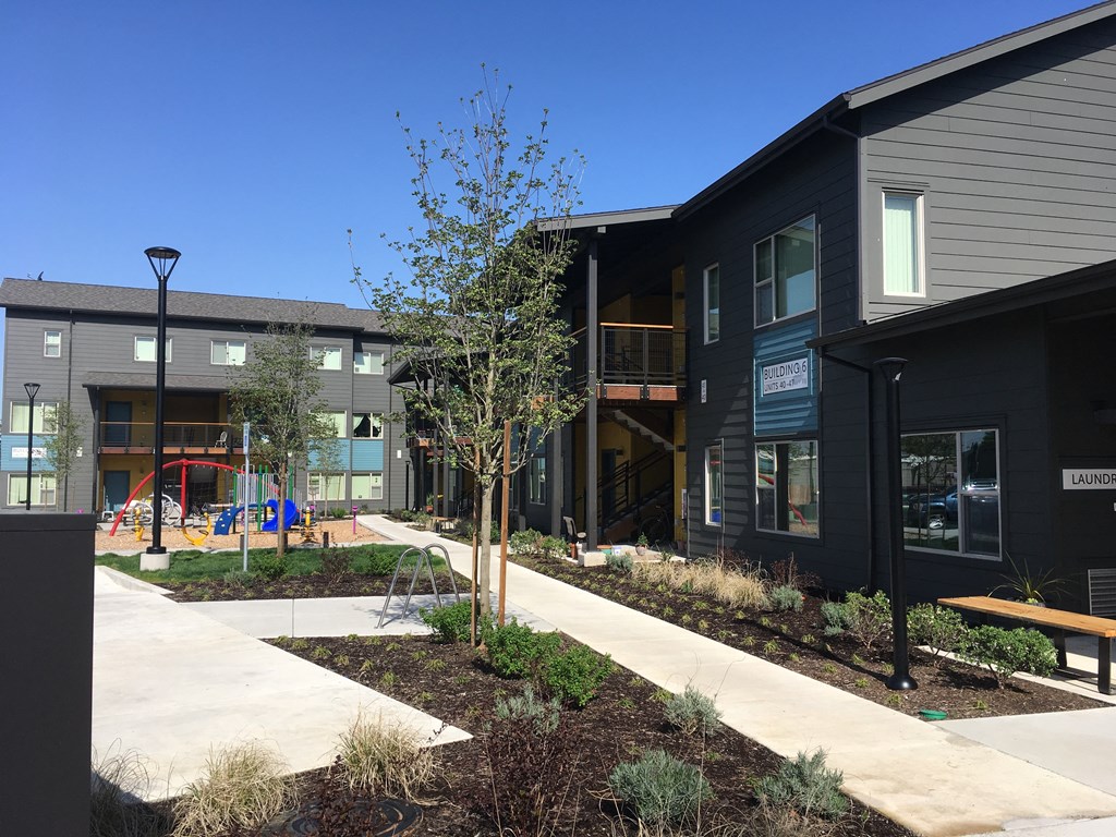 a view of the exterior of a building with a sidewalk and trees