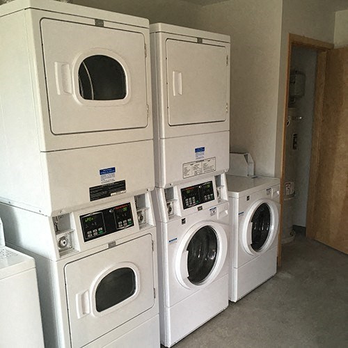 a bunch of washers and dryers in a laundry room