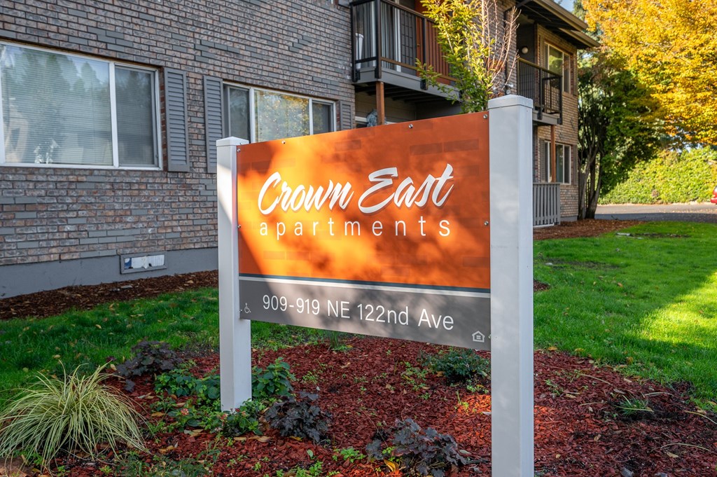 a sign in front of a building that reads crown east apartments