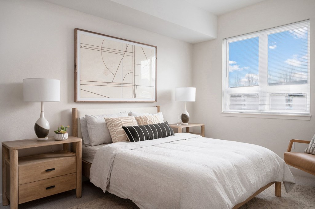 a bedroom with a large bed and two windows