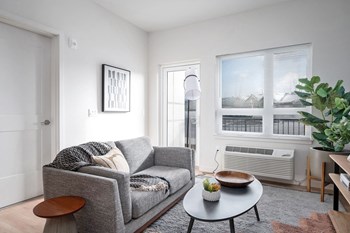 a small living room with a gray couch and a round coffee table - Photo Gallery 16