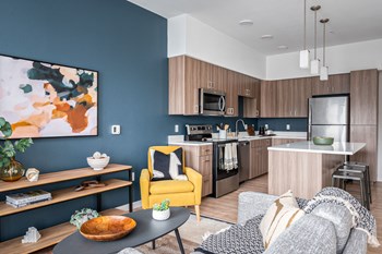 a living room and kitchen with blue walls and a yellow chair - Photo Gallery 8