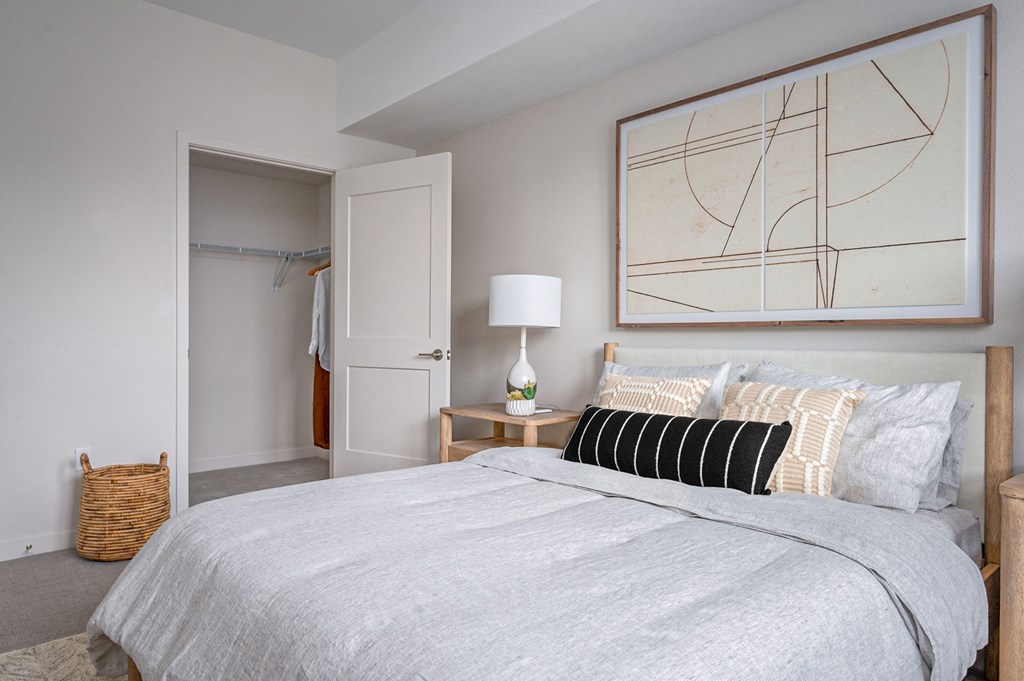 a bedroom with a bed and a nightstand with a lamp