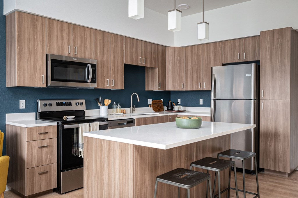 a kitchen with a large island and stainless steel appliances