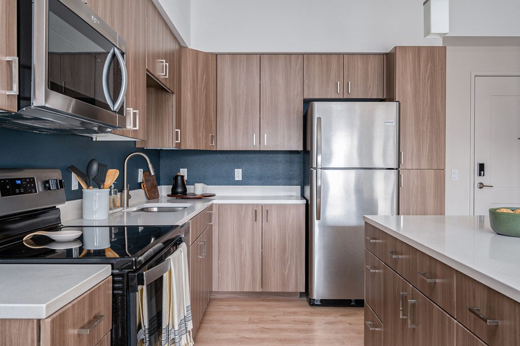 a kitchen with wooden cabinets and a stainless steel refrigerator