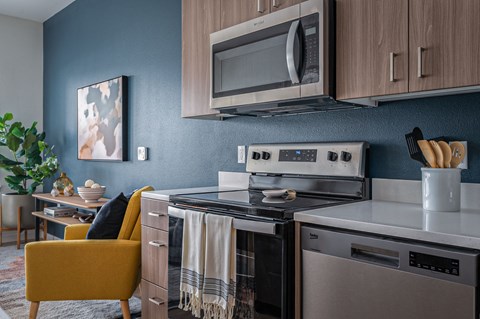 a kitchen with a stove and microwave and a table with a yellow chair