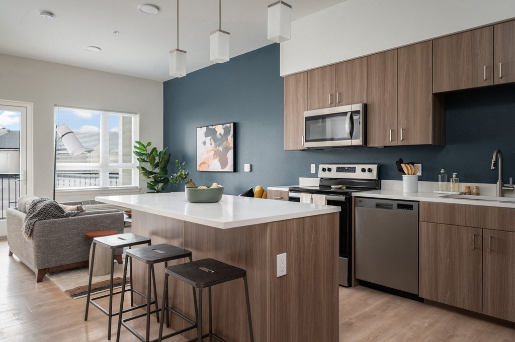 a kitchen with an island and stools in a 555 waverly unit