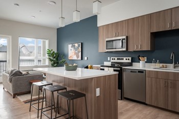 a kitchen with an island and stools in a 555 waverly unit - Photo Gallery 10