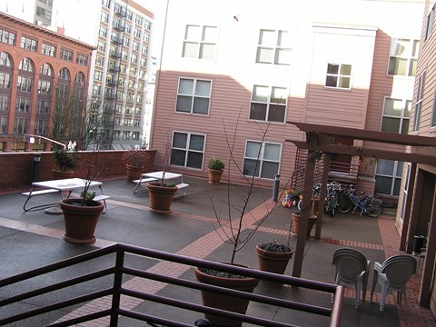 A patio with a table and chairs is surrounded by buildings.
