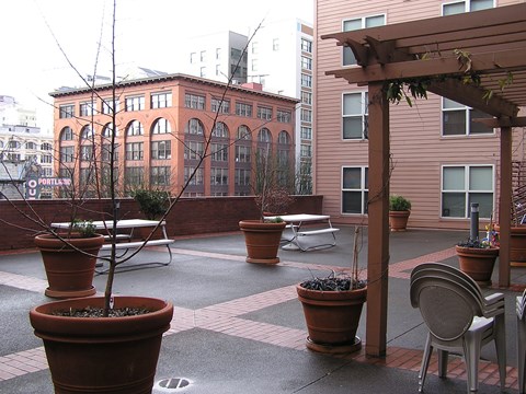 A patio with a table and chairs and potted plants.