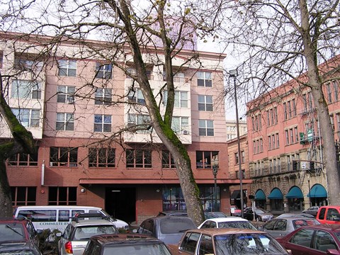 A parking lot with cars and a building in the background.