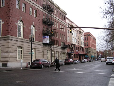 A city street with a person walking across the road.